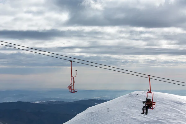 Patinador descansando en charilift en montaña — Foto de Stock