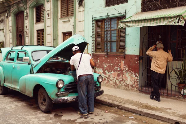 Havana, Küba'da klasik bir araba üzerinde çalışan insanlar — Stok fotoğraf