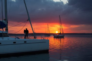 Couple in love on sailboat at sunset clipart