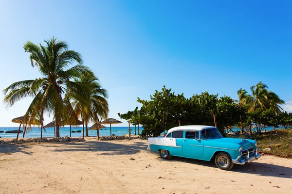 Gamla klassiska bil på stranden på Kuba — Stockfoto