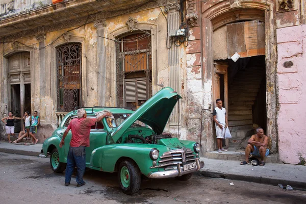 HAVANA - FEVEREIRO 25: Carro clássico e edifícios antigos em 25 de fevereiro de 2015 em Havana. Estes carros antigos são uma vista icónica da ilha — Fotografia de Stock