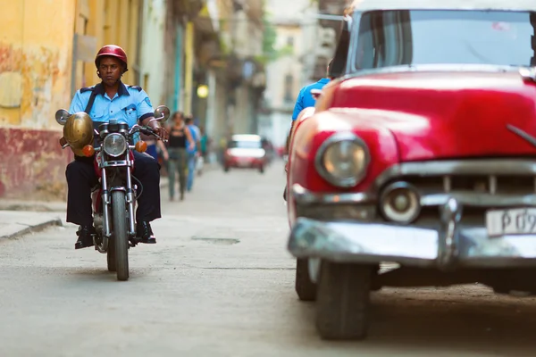 Havana - 25. února: Neznámý policie muž na kole a staré klasiky — Stock fotografie