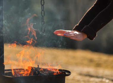 Bir kamp içinde bir ızgara ellerde ısınma kadın