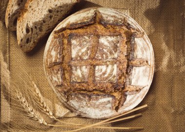 Rustic bread and wheat on a traditional cloth clipart