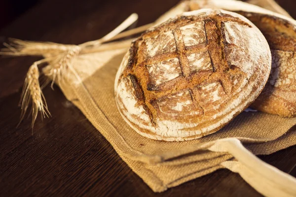 Bauernbrot und Weizen auf einer traditionellen Stofftasche — Stockfoto