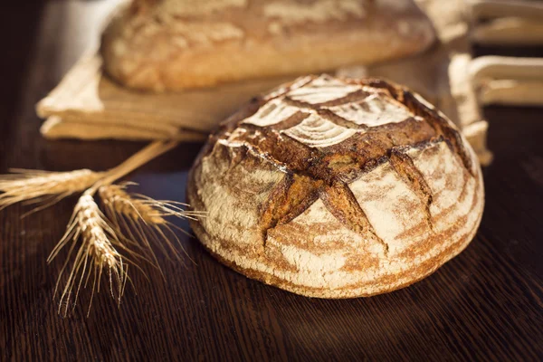 Bauernbrot und Weizen auf einer traditionellen Stofftasche — Stockfoto