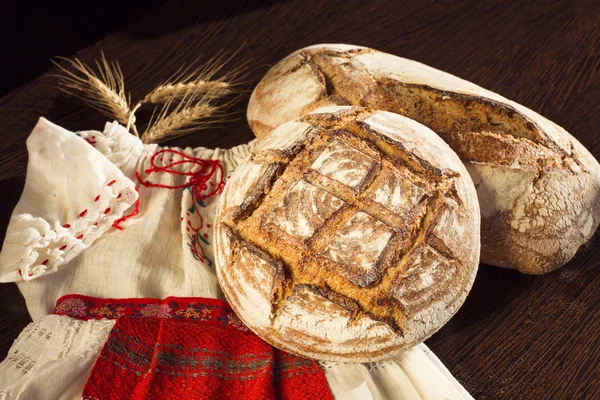 Bauernbrot und Weizen auf einem traditionellen Mädchenkostüm — Stockfoto