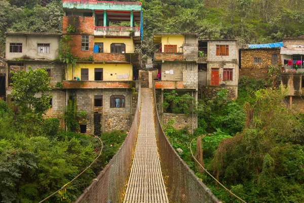 Touw opknoping hangbrug in Nepal met kleurrijke dorp in — Stockfoto