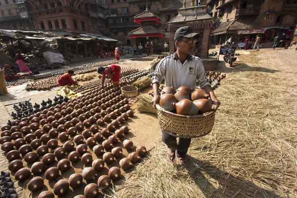 BAKTAPUR, NEPAL - NOVEMBRO 20: Homem não identificado carregando panelas — Fotografia de Stock