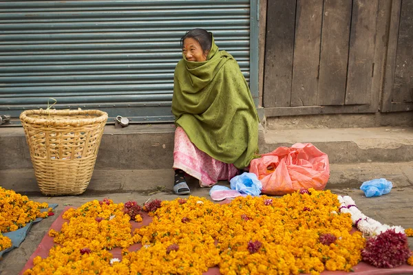 DURBAR SQUARE, KATHMANDU, NEPAL - NOVEMBER 28, 2014: Woman selli — Stock Photo, Image