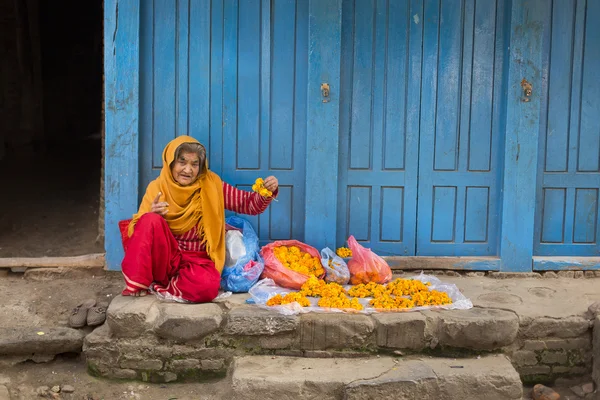 DURBAR SQUARE, KATHMANDU, NEPAL - NOVEMBER 30, 2014: Woman selli — Stock Photo, Image