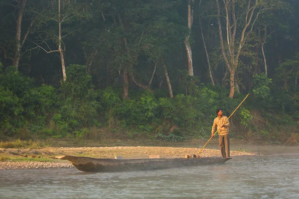 Chitwan, Nepal - 23. November 2014: Einheimischer mit Ruderboot unterwegs Stockbild