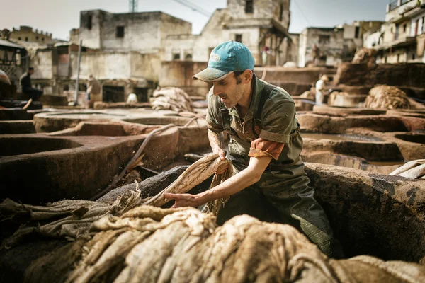 FEZ, MARRUECOS - 19 DE ABRIL: Los trabajadores de la fábrica de cuero realizan la —  Fotos de Stock