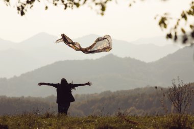 güzel bir genç kadın renkli peçete ile yeşil çayır üzerinde atlama