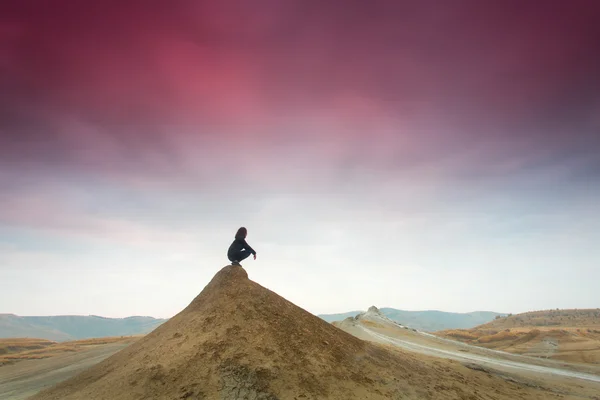 Siluett av kvinna mediterar på toppen av en kulle — Stockfoto