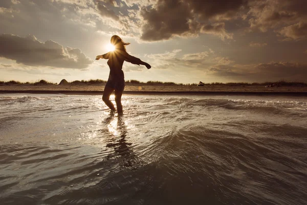 Mujer joven en el mar abrazando el mundo y las olas —  Fotos de Stock