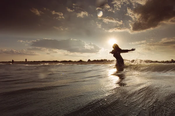 Young woman on sea embracing the the world and the waves — Stock Photo, Image