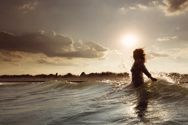 Mujer joven en el mar abrazando el mundo y las olas —  Fotos de Stock