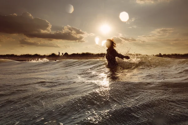 Mujer joven en el mar abrazando el mundo y las olas —  Fotos de Stock