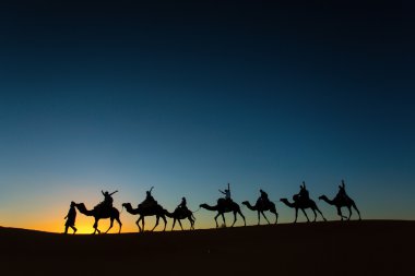 Sillhouette mutlu peopple th gidiş ile deve karavan