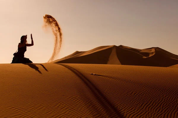 Silhouette Frau spielt und wirft mit Sand in Wüste saha — Stockfoto