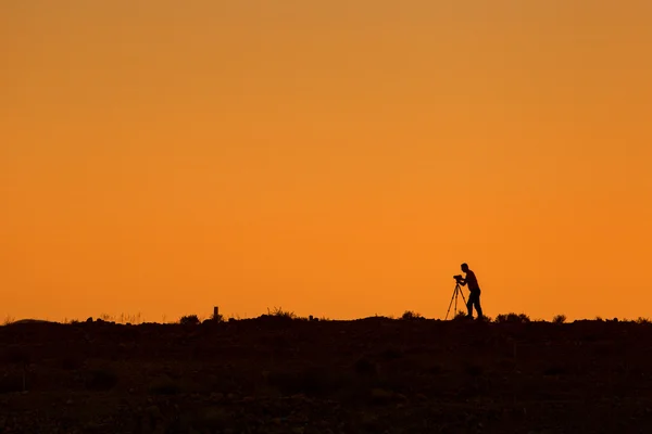 Silhouette of photographer during sunset with tripod — Stock Photo, Image