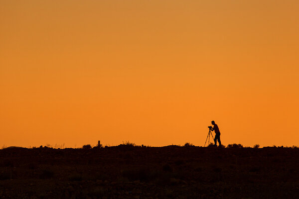 Silhouette of photographer during sunset with tripod