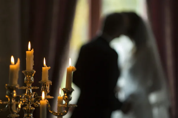 Candles and silhouette of the bride and groom at a wedding. — Stock Photo, Image