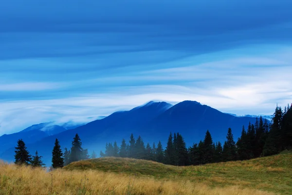 Dramatische bewegende wolken met berg silhouett — Stockfoto