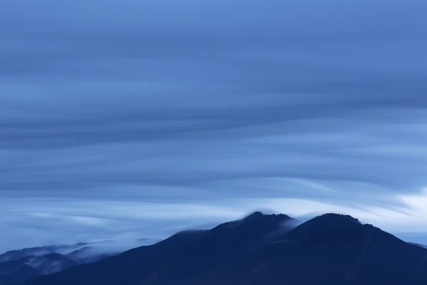 Dramatische wolken met berg silhouet — Stockfoto