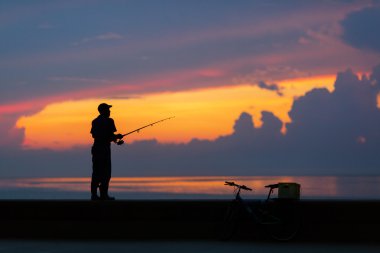 Balıkçı siluet renkli sunse plaj