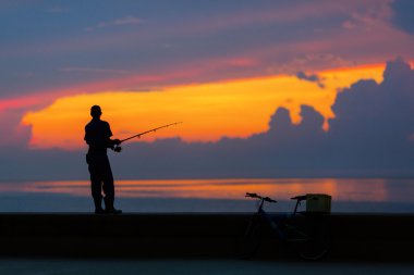 Balıkçı siluet renkli sunse plaj