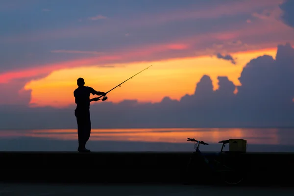 Sílhueta de pescador na praia em sunse colorido — Fotografia de Stock