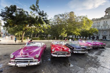 HAVANA, CUBA-OCTOBER 14: Man washing old car on streets of Havan clipart