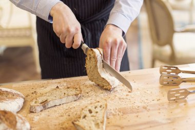 Adam ahşap bir gemide eve ekmek dilimleme