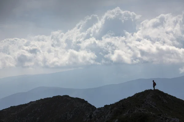Sziluettjét hegymászó fiatal felnőtt a tetején a csúcs aer — Stock Fotó