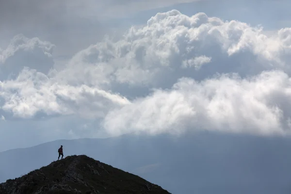 Silhouet van klimmen jonge volwassene boven aan de top met aer — Stockfoto