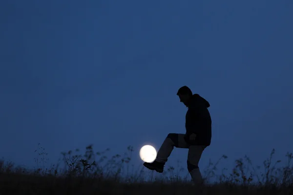 Sillhouette of man playing with the moon in night — Stock Photo, Image