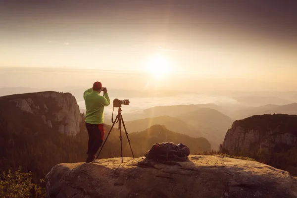 Fotografo che scatta foto all'alba sulle montagne — Foto Stock