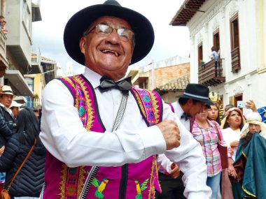 uenca, Ekvador - 24 Aralık 2019: Noel Geçit Pase del Nino Viajero (Gezgin Çocuk). Geçit törenine katılan bir grup dansçıyla kıdemli bir adam. Olay UNESCO 'nun soyut mirası