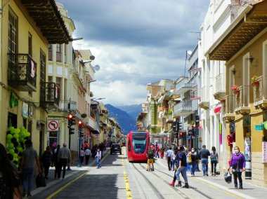 Cuenca, Ekvador - 22 Aralık 2020: Cuenca 'nın tarihi merkezi Mariscal Lamar' da Red City tramvayı (tramvay). COVID-19 salgını sırasında koruyucu maskeli vatandaşlar