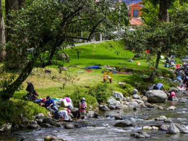 Cuenca, Ekvador - 1 Temmuz 2021: Yerel halk geleneksel olarak Cuenca kentini geçen Tomebamba nehrinde çamaşır yıkıyor