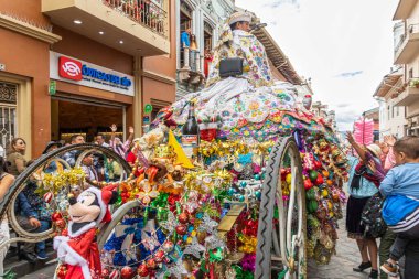 Cuenca, Ekvador 24 Aralık 2024: Pase del Nio Viajero bebek İsa 'nın onuruna düzenlenen bir Noel alayı. Büyük, zengin bir şamandıra ve geleneksel işlemeli Noel elbisesi giymiş bir kadın.