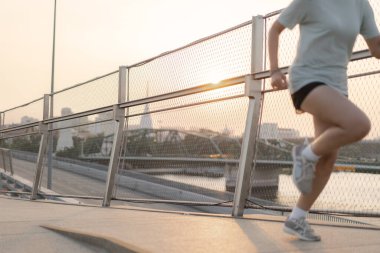 Egzersiz için koşan bir kadınla gün batımı