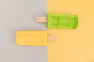 Dondurma çubuğu gri ve sarı arka planda.