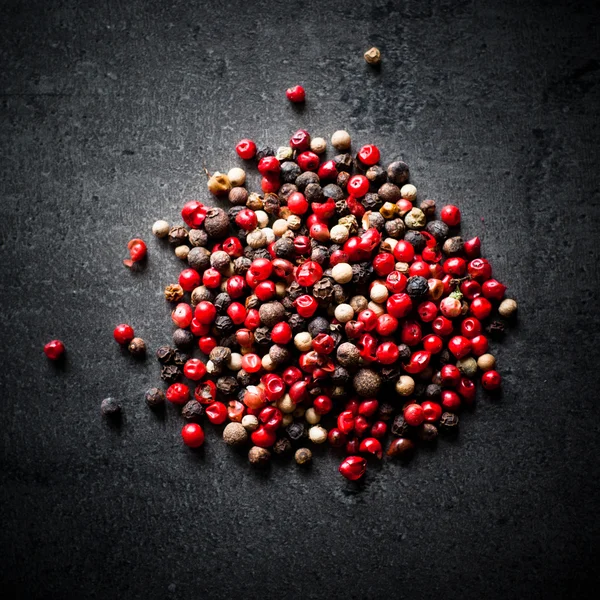 Peppercorns on a dark background — Stock Photo, Image
