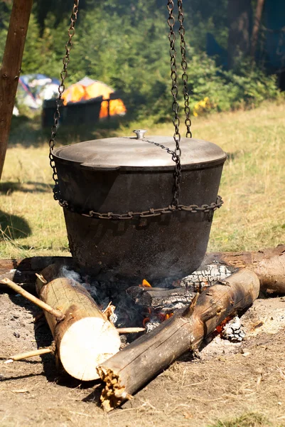 Matlagning i en stor gryta på elden. — Stockfoto
