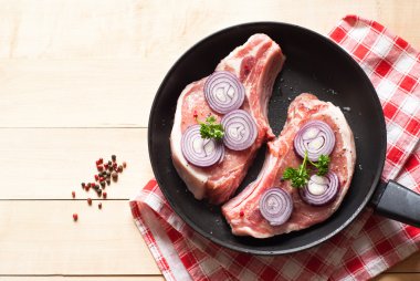 Bir tavada çiğ domuz eti.