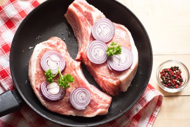 Bir tavada çiğ domuz eti.