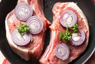 Bir tavada çiğ domuz eti.